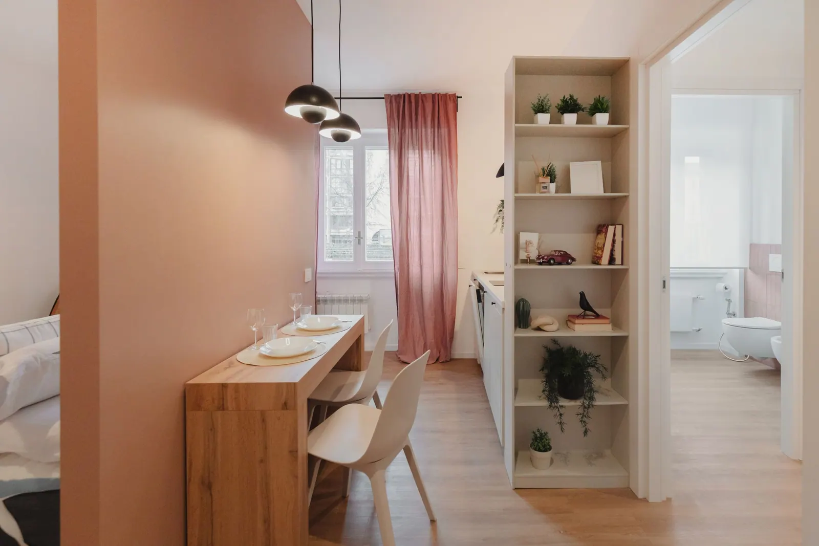 Mono Terracotta: zona giorno con parete terracotta, tavolo e libreria